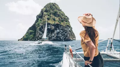 photo du rocher du diamant d'un voilier avec une femme de dos en premier plan