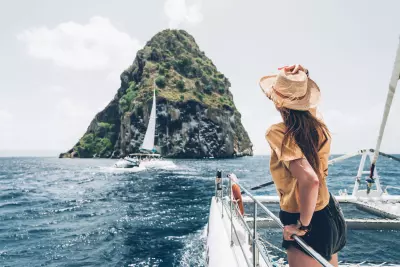 photo du rocher du diamant d'un voilier avec une femme de dos en premier plan