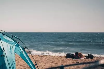 photo d'une tente sur le sable en face de la mer