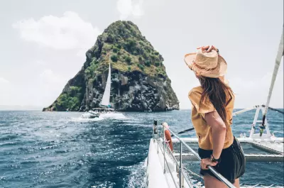 photo du rocher du diamant d'un voilier avec une femme de dos en premier plan