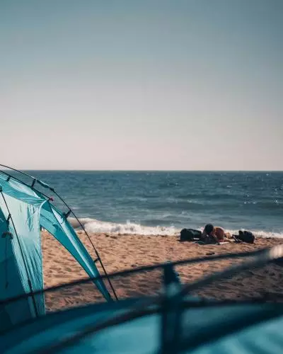 photo d'une tente sur le sable en face de la mer